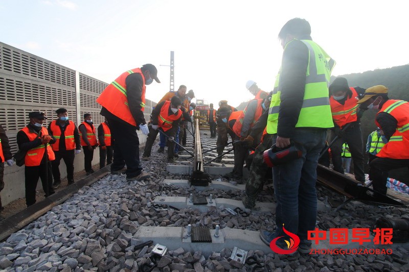 1610801074109804.jpg 图3-工人接引铺轨机吞吐长钢轨。.jpg