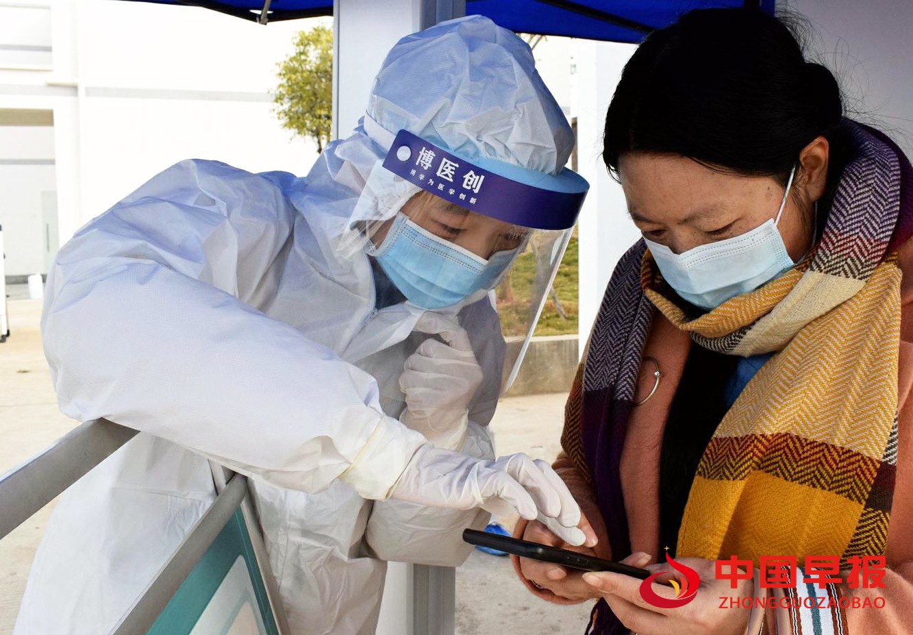 1611830176420667.jpg 图为指导居民扫健康码.jpg